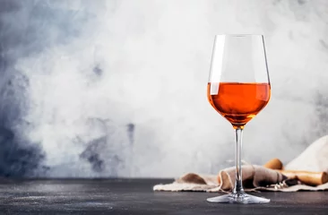 Foto op Canvas Trendy food and drink, orange wine in glass, gray table background, space for text, selective focus © 5ph