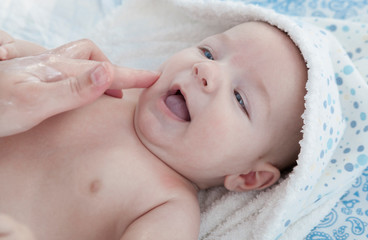 Applying cream over three months baby boy after bath