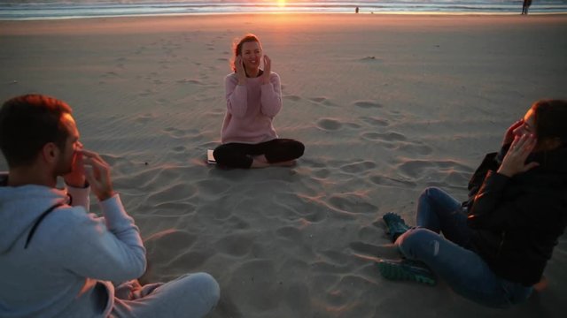 Yoga session on the beach with coach men and woman.
