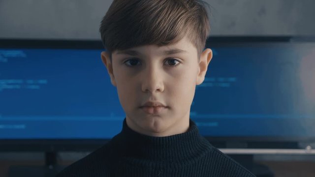 Prodigy Boy Hacker Programmer at data center filled with monitor screens