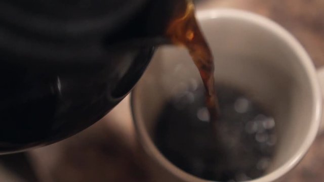 Man pouring cup of coffee. POV. 50% speed. Shallow depth of field.