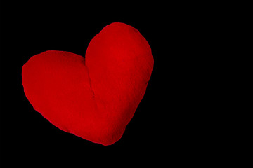 Isolated red textile soft toy heart on a black background. Object for art collage. Copy space.