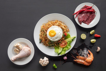 Asian dish fried noodles with egg and seafood or beef or chicken