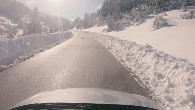 Driving on a snowy mountain road, sunny weather. Approaching Ziria ski center in Greece.