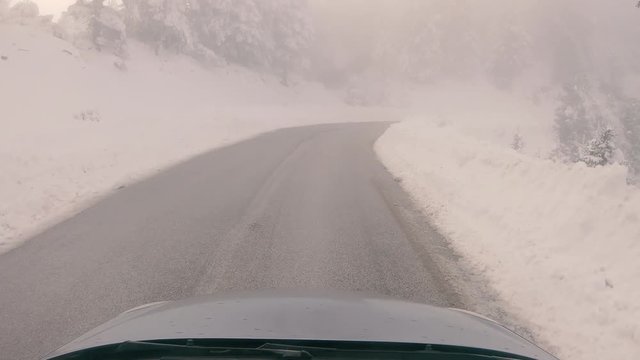 Driving through the fog on a snowy mountain road to Ziria ski center in Greece.