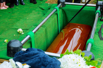 Burying a coffin at cemetery during a funeral ceremony