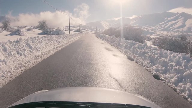 Driving on a snowy mountain road, sunny weather. Approaching Ziria ski center in Greece.