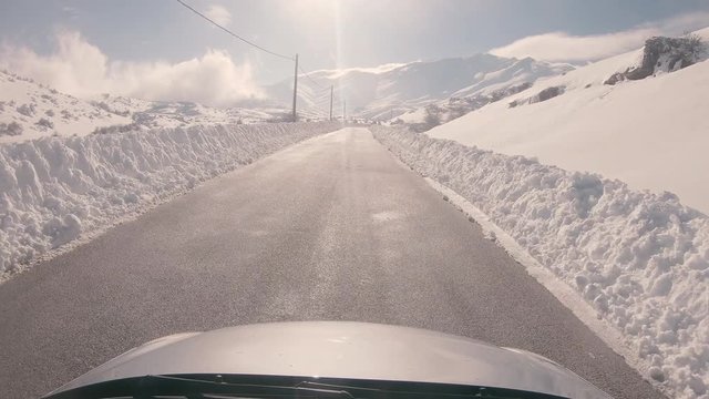 Driving on a snowy mountain road, sunny weather. Approaching Ziria ski center in Greece.