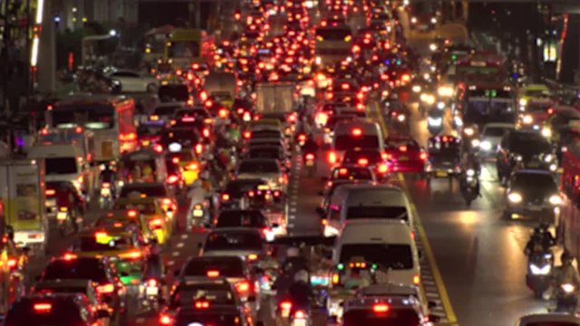 BANGKOK,  THAILAND - CIRCA OCTOBER 2018 : Blurred view of HEAVY RUSH HOUR TRAFFIC JAM near CHIT LOM train station.  Many CAR, BUS, TAXI, MOTORBIKE and TUK TUK on the road.
