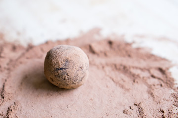 Close up image of raw dates, oats, linseed and chia seed energy balls rolled in cacao powder