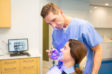 Female patient at dentis teeth whitening procedure