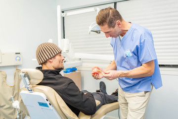 Obraz premium Dentist explains to patient on teeth mockup