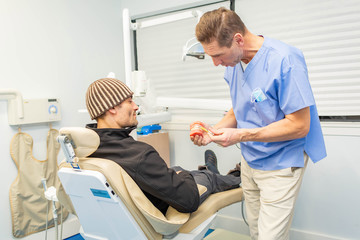 Obraz premium Dentist explains to patient on teeth mockup