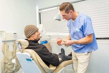 Obraz premium Dentist explains to patient on teeth mockup