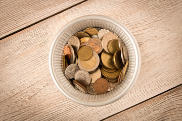 Different coins in a metal basket. The view from the top. The concept of poverty. The concept of savings.