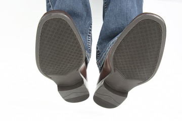 Male legs in jeans and brown classic shoes on white background