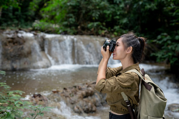 Female hikers take pictures of themselves with beautiful waterfalls. Relax after hiking