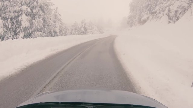 Driving through the fog on a snowy mountain road to Ziria ski center in Greece.