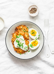 Potato latkes and boiled egg - healthy breakfast or snack on light background, top view