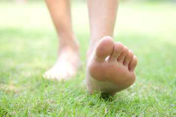 Leg of woman is on the ground. She is about to walk down the grass to exercise in the morning. Health and Relaxation Concepts