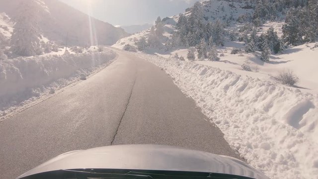 Driving on a snowy mountain road, sunny weather. Approaching Ziria ski center in Greece.