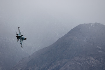 Fototapeta na wymiar Fighter jet maneuvering in a hazy winter sky