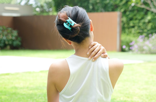 Women have neck pain, shoulder pain, at the park health concept.