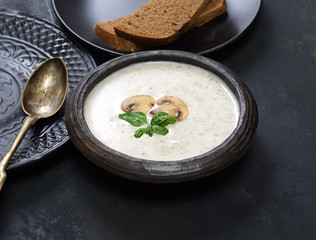 Mushroom cream soup on a Champignon on a dark background. Rustic style. 
