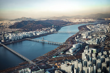 Fototapeta premium Aerial view cityscape of Seoul, South Korea. Aerial View Lotte tower at Jamsil. View of Seoul with river and mountain. Seoul downtown city skyline, Aerial view of Seoul