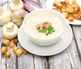 Champignon mushroom cream soup in bowl on wooden background. Rustic style. 