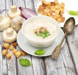 Champignon mushroom cream soup in bowl on wooden background. Rustic style. 