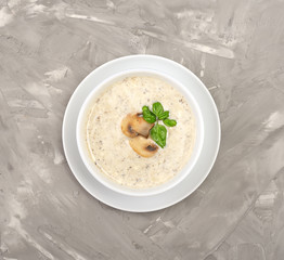 Champignon mushroom cream soup in bowl on gray background.  Top view.