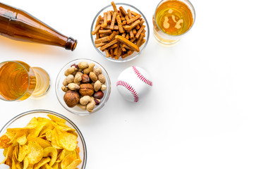 Snacks for watching american football on TV. Watching sports. Chips, nuts, rusks near beer and ball on white background top view copy space