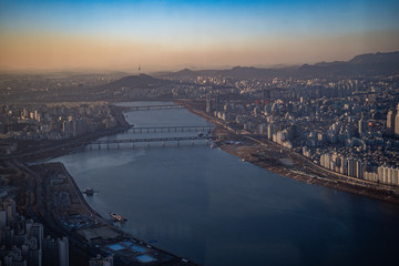 Fototapeta na wymiar Aerial view cityscape of Seoul, South Korea. Aerial View Lotte tower at Jamsil. View of Seoul with river and mountain. Seoul downtown city skyline, Aerial view of Seoul