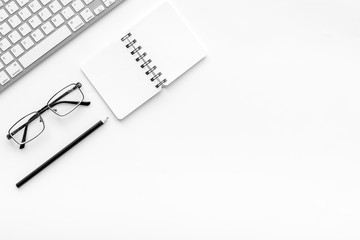 Office desk in order. Geometry. Computer keyboard and office supplies, glasses on white background top view copy space