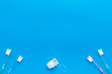 Oral hygiene. Plastic toothbrushes on blue background top view space for text