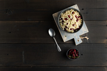 Pearl barley porridge in a plate on a black wooden background