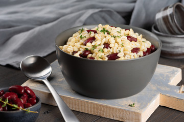 Pearl barley porridge in a plate on a black wooden background