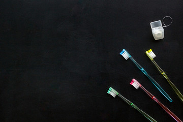 Oral hygiene. Plastic toothbrushes on black background top view space for text
