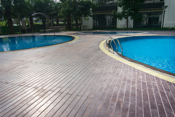 Blue swimming pool with wood flooring stripes