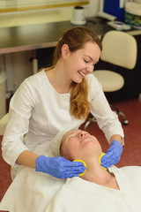 Young beautiful woman receiving facial massage and spa treatment in beauty salon