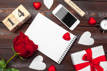 Valentine's day background. Empty blank notebook, gift box, flowers on a white background, top view. Free space for text