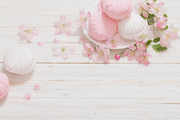 marshmallow with flowers on white wooden background