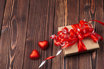 Gift box with red hearts on wooden table