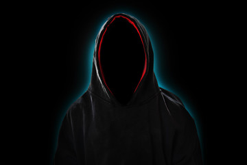 Man with hood in the dark with light shining behind, invisible man or hacker concept - obrazy, fototapety, plakaty