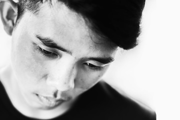 Depress and hopeless Boy with lower head on white in white tone,Child abuse concept