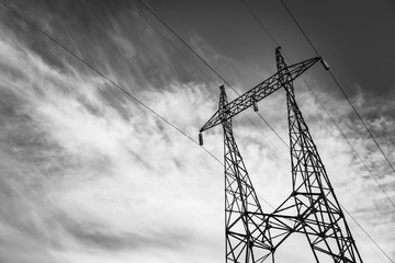 Electricity pole in black and white. Electricity pylon with clouds on the background. High voltage...