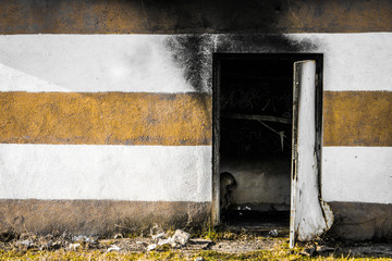 A partially burnt buildin with striped wall. Stripes on a wall. Charred building.