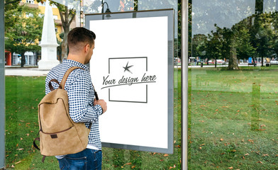 Man from looking at bus marquee poster