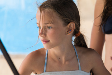 portrait of a beautiful young girl, 9-12 years old, in a swimsuit close-up